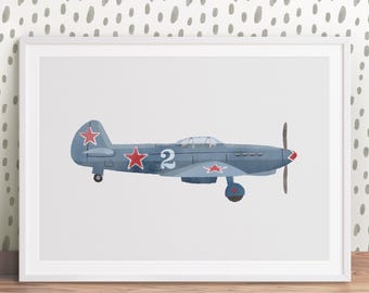 May include: A framed print featuring a blue airplane illustration. The aircraft has red star emblems and the number 2 on its side. The propeller and nose are red. The background is white, and the frame is white.