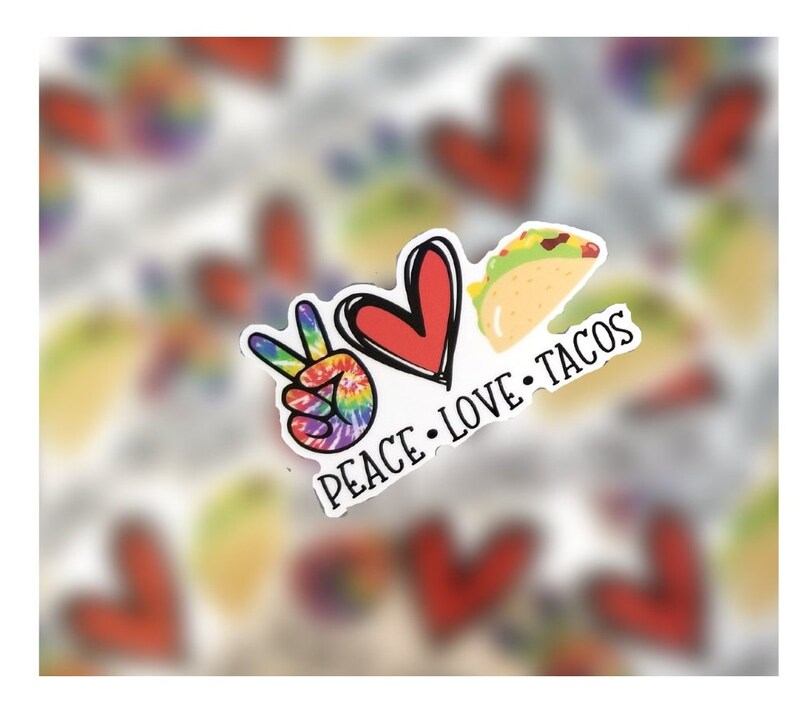 May include: Peace, love, and tacos sticker with a peace sign, heart, and taco graphic. The peace sign is rainbow tie-dye, the heart is red, and the taco is yellow with green lettuce and brown meat.