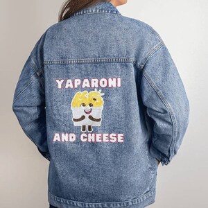 May include: A blue denim jacket with a cartoon character and the text "YAPARONI AND CHEESE" embroidered on the back.