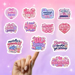 May include: A collection of eleven die-cut stickers featuring pink, purple, and blue color palettes with various text designs including 'certified fujoshi', 'yaoi for life', 'emotional support BL', 'plot twist survivor', 'I read BL', 'AO3 tabs', and 'BL ONLY NA'.