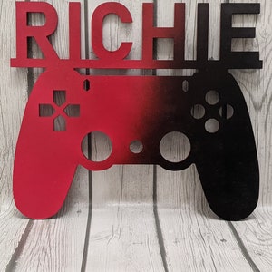 May include: A red and black wooden game controller with the name "RICHIE" above it. The controller is a popular design for video game consoles.