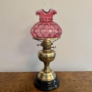 Pretty antique Edwardian brass oil lamp with cranberry glass shade