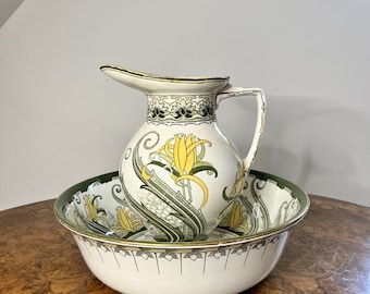 May include: A white ceramic jug and bowl set with a green and yellow floral design. The jug has a wide spout and a handle. The bowl is round and has a green rim.