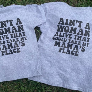K&ouml;nnte beinhalten: Zwei graue T-Shirts mit dem Text "Ain't a woman alive that could take my mama's place" in Schwarz auf der R&uuml;ckseite.