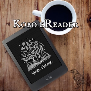 Könnte beinhalten: Ein schwarzer Kobo E-Reader mit einem weißen Blumenmuster auf dem Bildschirm. Der Bildschirm zeigt den Text "Your Name".