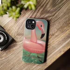 May include: A pink flamingo inflatable pool float phone case with a green and blue water background.