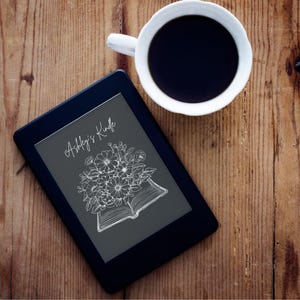 May include: A black and gray e-reader with a white floral design and the text "Ashley's Kindle" on the screen.
