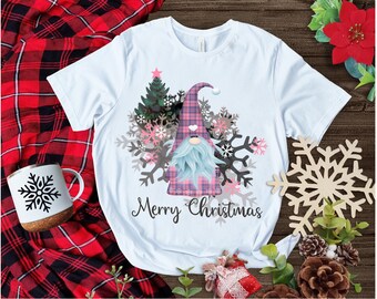 May include: White t-shirt with a pink and blue plaid gnome, a Christmas tree, and snowflakes. The text "Merry Christmas" is printed below the gnome.