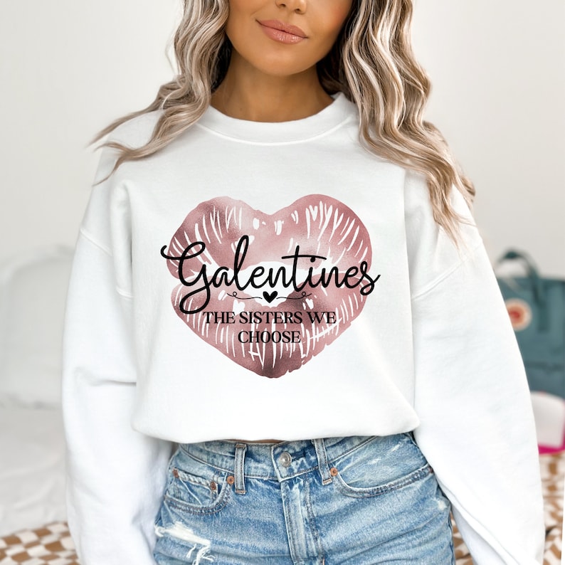 Puede incluir: Sudadera blanca con un gr&aacute;fico de labios en forma de coraz&oacute;n rosa y el texto "Galentines The Sisters We Choose".