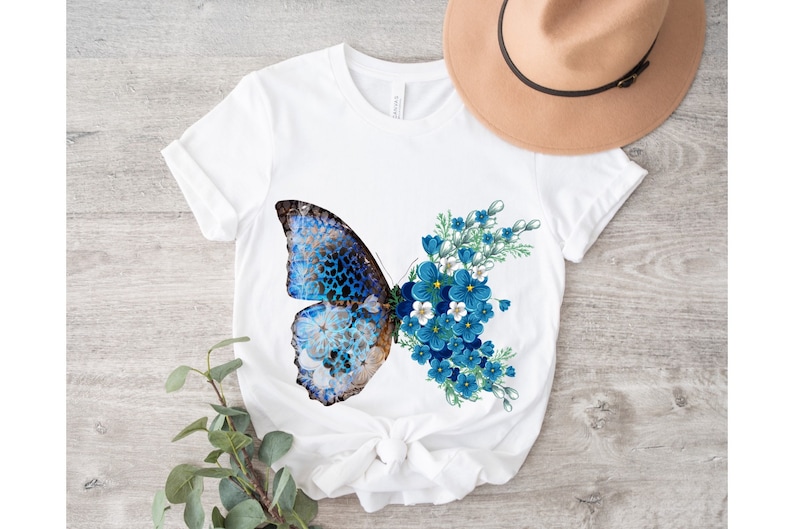 May include: White t-shirt with a blue butterfly and blue flowers printed on the front.