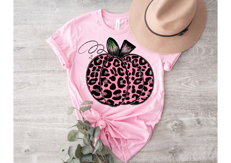 May include: Pink t-shirt with a black and pink leopard print pumpkin graphic.