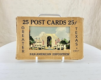 May include: Vintage postcard set featuring a color image of the Pan-American Exposition in Texas, 1937. The cardboard box reads "25 POST CARDS 25¢" with additional text "GREATER" and "TEXAS" on the sides.