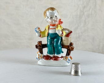 Occupied Japan 1950s 4" Figurine of Boy by a Fence Holding Flowers.