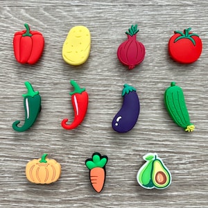 May include: A collection of colorful vegetable-shaped charms, including a red bell pepper, yellow potato, red onion, and a red tomato. Other charms include a green chili pepper, red chili pepper, purple eggplant, and a green cucumber. Also included are a pumpkin, carrot, and avocado.