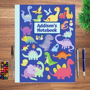 May include: A blue notebook with a dinosaur theme. The cover features a variety of colorful dinosaurs, including a green triceratops, a purple stegosaurus, and a red brachiosaurus. The text "Addison's Notebook" is printed in white on a blue rectangle in the center of the cover.