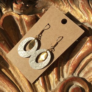 Gold and white shimmer leather earrings with a brushed wavy brass charm.
