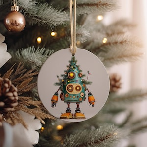 May include: A round Christmas ornament featuring a robot designed as a Christmas tree. The robot is teal with orange accents, and has a string for hanging. The ornament is hanging on a Christmas tree.