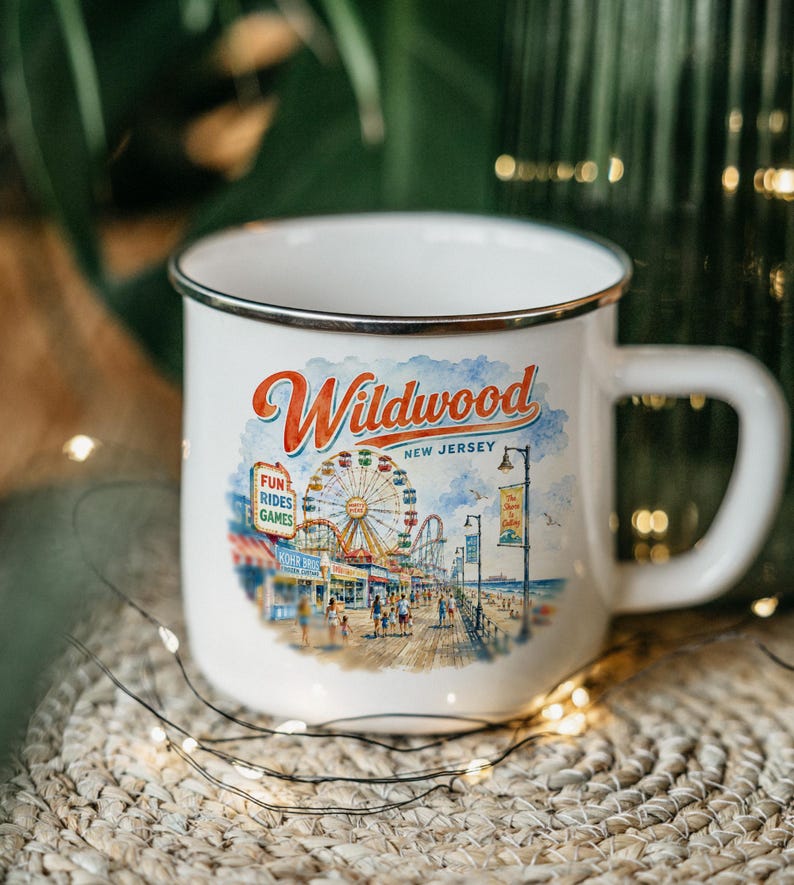 A white enamel mug with a printed design depicting a carnival scene in New Jersey.