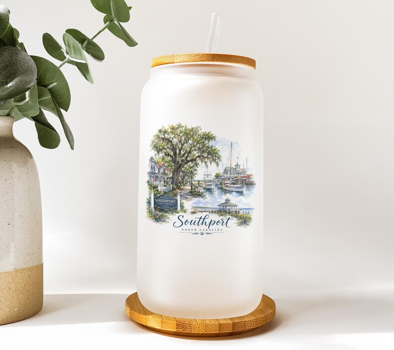 A frosted glass jar with a printed image of a coastal scene, including a tree, boats, and buildings, along with the text "Southport" and "SOUTHPORT, FL".