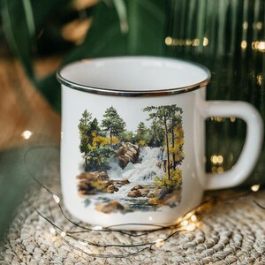 a coffee cup with a picture of a waterfall on it