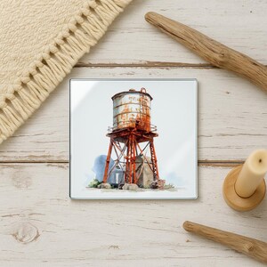 May include: Square glass coaster featuring a watercolor painting of a rusty water tower. The tower is painted in shades of red, brown, and gray, with a ladder and support structure. The coaster is set against a white background.
