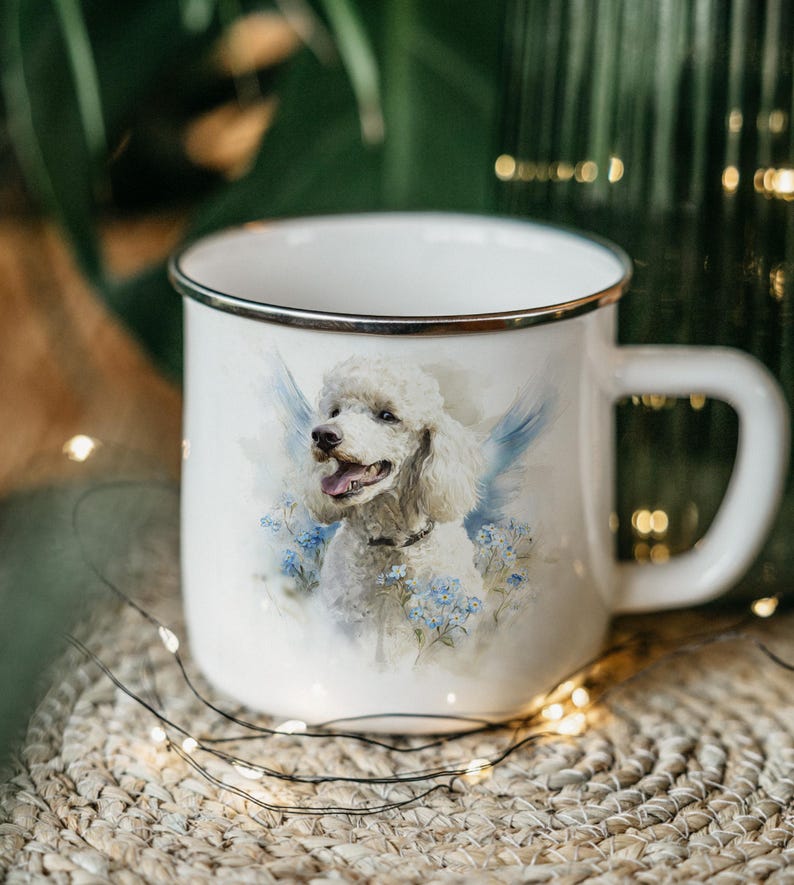 A white ceramic mug with a picture of a poodle on it, placed on a woven mat with twinkling lights in the background.