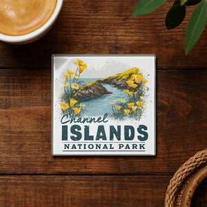 A coaster with a scenic image of the Channel Islands National Park, featuring a rocky coastline, water, and yellow flowers.