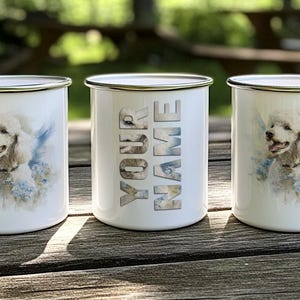Three white ceramic mugs with images of poodles on them, placed on a wooden surface.