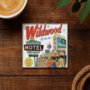 A vintage-style metal coaster with a retro-style illustration of a motel called Wildwood by the Sea, featuring a woman walking on a boardwalk and a man in a striped shirt.