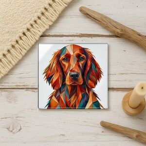 May include: A square coaster featuring a geometric, multi-colored illustration of an Irish Setter dog. The dog's fur is rendered in shades of orange, red, brown, and teal, creating a faceted, stained-glass effect against a white background.