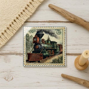 May include: Square coaster featuring a vintage illustration of a green and red steam train on tracks, emitting black smoke. The image is framed with a postage stamp border and the text "Postless One".