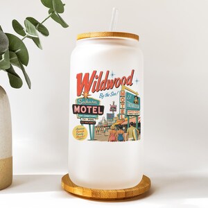 A white ceramic mug with a label that says "Wildwood Motel" and features an illustration of a motel scene with people and neon signs.