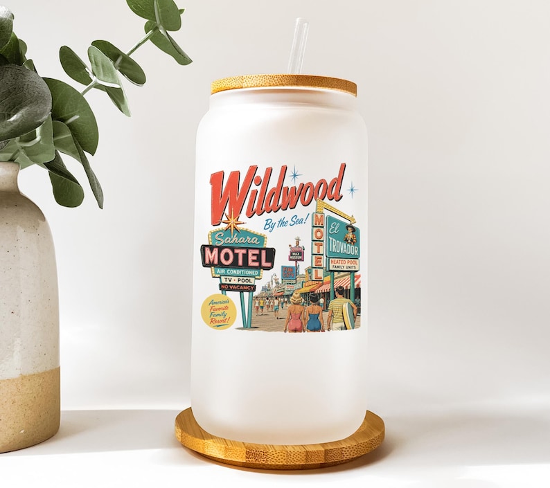 A white ceramic mug with a label that says "Wildwood Motel" and features an illustration of a motel scene with people and neon signs.