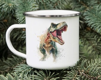 May include: White enamel mug with a silver rim featuring a watercolor illustration of a Tyrannosaurus Rex with an open mouth. The dinosaur is depicted in shades of green, brown, and red. The mug has a white handle and is set against a background of green foliage.
