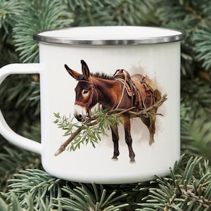 May include: White enamel mug with a detailed illustration of a brown donkey wearing a saddle and bridle, standing on a branch with green leaves. The mug has a silver rim and a white handle.