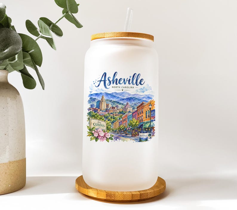 A white ceramic mug with a label that says "Ashville, North Carolina" and features an illustration of a cityscape.