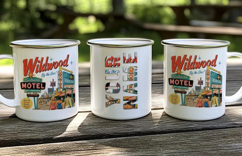 Three vintage-style mugs with the text "Wildwood By the Sea" printed on them, placed on a wooden surface.
