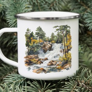 a white coffee mug with a picture of a waterfall on it
