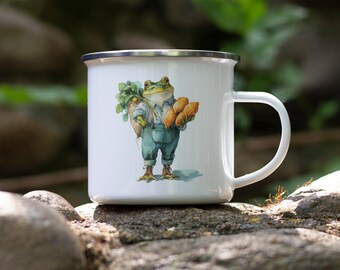 May include: White enamel mug with a whimsical illustration of a frog dressed in overalls, carrying carrots and bread. The mug has a silver rim and a white handle. The design is a charming, rustic style.