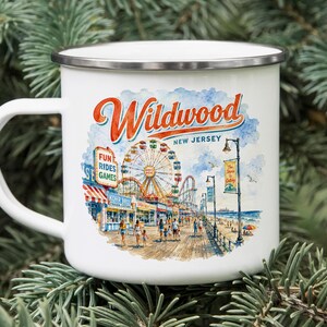 A white enamel mug with a printed illustration of a boardwalk and amusement park in New Jersey.