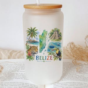 May include: Frosted glass tumbler with a bamboo lid and straw. The tumbler features a colorful Belize design with a jaguar, toucan, palm trees, and the word "BELIZE". The design is a watercolor style.