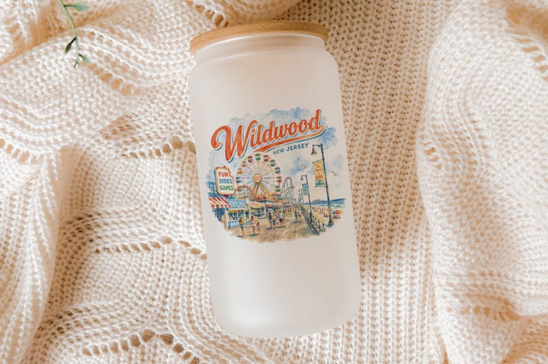 A frosted glass jar with a printed design of a carnival scene, placed on a white knitted blanket.