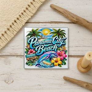 May include: A square coaster featuring a colorful graphic of Panama City Beach with a leaping dolphin, bright hibiscus flowers, palm trees, and a yellow sun. The text reads Panama City Beach and Paradise Awaits on a wooden sign graphic.