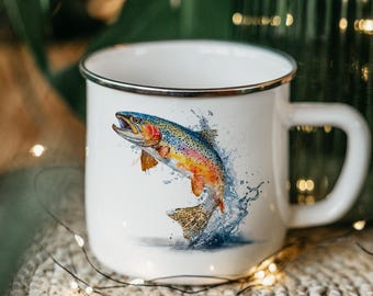 May include: White enamel mug with a silver rim, featuring a watercolor illustration of a jumping rainbow trout. The fish is depicted with vibrant colors, including blue, yellow, orange, and red. The mug has a large handle and is set against a blurred background.