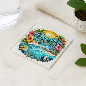May include: A square coaster featuring a vibrant graphic of Panama City Beach with a sunny coastal scene, turquoise ocean waves, colorful tropical hibiscus flowers, palm trees, and several small striped fish swimming in the foreground.