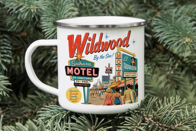 A white mug with a vintage-style illustration of a motel called Wildwood by the Sea, featuring neon signs and people enjoying the beach.