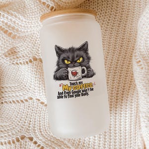 May include: Frosted glass tumbler with a wooden lid. The tumbler features a graphic of a grumpy black cat holding a coffee mug. Text on the tumbler reads "Touch my coffee and even Google won't be able to find your body."
