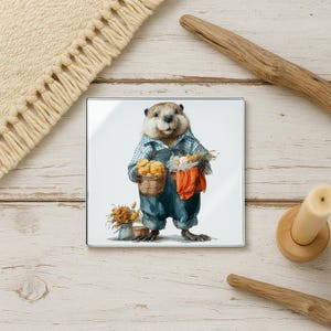 May include: Square glass coaster featuring a watercolor illustration of a groundhog wearing overalls and a plaid shirt, holding baskets of produce. The groundhog is standing on a white background. Dried flowers are in a small vase. The coaster is on a wooden surface.