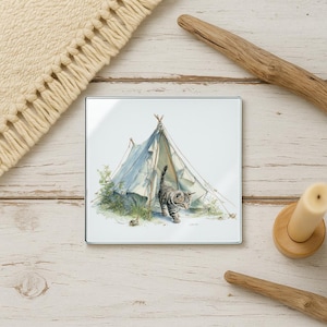 May include: Square glass coaster featuring a watercolor illustration of a gray tabby kitten walking out of a light blue teepee tent. The coaster has a white background with green foliage and a small mouse.