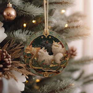 A Christmas tree decorated with ornaments, including a circular ornament featuring three cats on a sleigh.